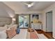 Comfortable bedroom with natural light, balcony access, and a view of a wooded area at 5400 Roswell Rd # N1, Sandy Springs, GA 30342