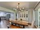Open-concept dining room featuring a modern chandelier, white hutch, wood table and access to kitchen at 5400 Roswell Rd # N1, Sandy Springs, GA 30342