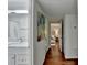 Hallway view with bathroom and bedroom access, enhanced by a nature-themed painting at 5400 Roswell Rd # N1, Sandy Springs, GA 30342