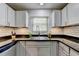 Updated kitchen featuring white cabinets, granite countertops, stainless steel sink, and subway tile backsplash at 5400 Roswell Rd # N1, Sandy Springs, GA 30342