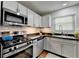 Well-lit kitchen with stainless steel appliances, white cabinets, subway tile backsplash, and a stainless sink at 5400 Roswell Rd # N1, Sandy Springs, GA 30342