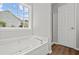 Bright bathroom features a jacuzzi tub, shower, and a view from the window at 102 Pine Bark Dr, Villa Rica, GA 30180