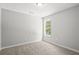 A cozy carpeted bedroom with natural light from a window at 102 Pine Bark Dr, Villa Rica, GA 30180