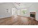 Cozy living room with wood-look floors, a vaulted ceiling, fireplace, and ample natural light at 102 Pine Bark Dr, Villa Rica, GA 30180