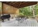 Back porch with a grill and patio furniture with a view of landscaping and a stone water feature at 230 Ridge Point Ct, Alpharetta, GA 30022