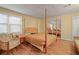 Bedroom featuring a four-poster bed, wood floors, and a large mirrored closet at 230 Ridge Point Ct, Alpharetta, GA 30022