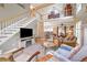 Comfortable living room featuring a fireplace, wooden floors, and a staircase leading up at 230 Ridge Point Ct, Alpharetta, GA 30022