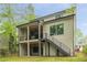Large backyard with a two-story porch, stairs to the yard, and plenty of green grass and trees at 253 Rockyford Ne Rd, Atlanta, GA 30317