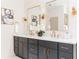 Stylish bathroom with dual sinks, granite counters, dark cabinetry, and elegant mirrors and light fixtures at 253 Rockyford Ne Rd, Atlanta, GA 30317