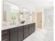 Elegant bathroom with dual sinks, granite counters, dark cabinetry, and a glass-enclosed shower for a luxurious experience at 253 Rockyford Ne Rd, Atlanta, GA 30317