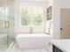 Bright bathroom featuring a modern freestanding tub, a glass-enclosed shower, and elegant gold fixtures and fittings at 253 Rockyford Ne Rd, Atlanta, GA 30317