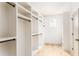 Walk-in closet providing ample storage, featuring built-in shelves and rods, plus natural light from a window at 253 Rockyford Ne Rd, Atlanta, GA 30317