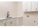 Functional laundry room featuring white cabinetry, ample countertop space, and modern black hardware at 253 Rockyford Ne Rd, Atlanta, GA 30317