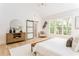 Sun-drenched main bedroom featuring a large window, a sliding door, stylish furniture, and hardwood flooring at 253 Rockyford Ne Rd, Atlanta, GA 30317