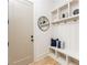 Bright mudroom with built-in shelving, coat hooks, bench, and round mirror, creating an organized and stylish entryway at 253 Rockyford Ne Rd, Atlanta, GA 30317