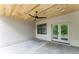 Covered patio with wood ceiling, ceiling fan, concrete floor, and view to the backyard through french doors at 253 Rockyford Ne Rd, Atlanta, GA 30317