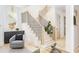 Inviting staircase with natural wood treads, black iron railings, and a gray accent chair for a stylish, modern aesthetic at 253 Rockyford Ne Rd, Atlanta, GA 30317