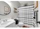 Bright bathroom featuring a round mirror, decorative shelves, and a stylish patterned shower curtain at 3477 Seneca Farm Dr, Buford, GA 30519