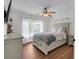 Charming bedroom with a ceiling fan, bright window, and light grey walls and wood flooring at 3477 Seneca Farm Dr, Buford, GA 30519