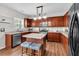 Well-equipped kitchen with stainless steel appliances, center island with seating, and hardwood floors at 3477 Seneca Farm Dr, Buford, GA 30519