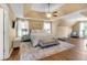 Spacious main bedroom with a tray ceiling, ceiling fan, and a cozy seating area for relaxation at 3477 Seneca Farm Dr, Buford, GA 30519