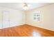Bright bedroom featuring hardwood floors, a ceiling fan, and a large window at 2227 Leafmore Drive, Decatur, GA 30033