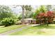 Quaint home featuring a well-kept lawn, driveway, and landscaping, set amongst mature trees at 2227 Leafmore Drive, Decatur, GA 30033