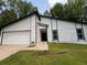 White home with a two-car garage and stone accent near the main entrance at 3285 Rollingbrook Way, Duluth, GA 30096