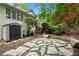 Landscaped backyard featuring a stone patio, storage shed and steps up to a lush, wooded area at 4152 Barberry Ne Dr, Roswell, GA 30075