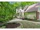 Charming home's outdoor space features a lush garden, stone patio, and wooded views at 4152 Barberry Ne Dr, Roswell, GA 30075
