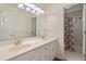 Well-lit bathroom features a double sink vanity, a large mirror and a shower with patterned curtain at 4152 Barberry Ne Dr, Roswell, GA 30075