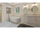 Bright bathroom boasts a standalone tub, marble floors, and double vanity at 4152 Barberry Ne Dr, Roswell, GA 30075