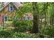 Charming brick home with blue shutters, lush landscaping, and a serene garden bench at 4152 Barberry Ne Dr, Roswell, GA 30075