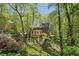 A view of the home set amongst lush greenery on an inclined lot at 4152 Barberry Ne Dr, Roswell, GA 30075