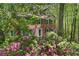 Inviting brick home with a white door, surrounded by lush greenery and vibrant blooming flowers at 4152 Barberry Ne Dr, Roswell, GA 30075