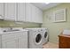 Well-organized laundry room with washer, dryer, sink, and ample cabinet space at 4152 Barberry Ne Dr, Roswell, GA 30075
