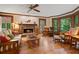 Bright living room featuring a brick fireplace, hardwood floors, wood trim, ceiling fan, and natural light at 4152 Barberry Ne Dr, Roswell, GA 30075