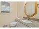 Powder room with granite countertop, white vanity and framed mirror with window at 4152 Barberry Ne Dr, Roswell, GA 30075
