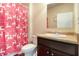 Well-lit bathroom with a single sink vanity, toilet, and a shower featuring a festive shower curtain at 8484 Glenview St, Douglasville, GA 30134
