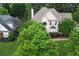 Aerial view of a two-story home with a lush yard, surrounded by mature trees and neighboring houses at 1035 Eagles Brooke Dr, Locust Grove, GA 30248