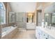 Bathroom features a bathtub, glass enclosed shower, and double sink vanity at 1035 Eagles Brooke Dr, Locust Grove, GA 30248