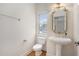 Powder room featuring a pedestal sink, decorative mirror, and natural light from the window at 1035 Eagles Brooke Dr, Locust Grove, GA 30248