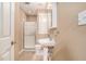 Compact bathroom showcasing a pedestal sink, tiled floor, and a glass-enclosed shower stall at 1035 Eagles Brooke Dr, Locust Grove, GA 30248