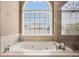 Bright bathtub with a large window and tile surround at 1035 Eagles Brooke Dr, Locust Grove, GA 30248