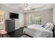 Bedroom with dark hardwood floors, TV, and ensuite bathroom offers space to relax at 1035 Eagles Brooke Dr, Locust Grove, GA 30248