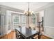 Formal dining room showcasing bay windows, chandelier, hardwood floors, and elegant trim work at 1035 Eagles Brooke Dr, Locust Grove, GA 30248