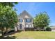 Two-story home with a manicured lawn and mature trees, creating a welcoming curb appeal at 1035 Eagles Brooke Dr, Locust Grove, GA 30248