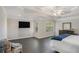 Spacious main bedroom boasts a tray ceiling, dark floors, TV, and bright windows overlooking the exterior at 1035 Eagles Brooke Dr, Locust Grove, GA 30248