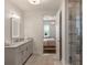 Bright bathroom with double vanity, granite counters, and glass enclosed shower next to the bedroom at 50 Canton St # 406, Alpharetta, GA 30009