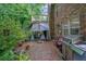 Outdoor patio with brick flooring, grill, and view of lush backyard greenery at 842 Laurel Crest Sw Ct, Marietta, GA 30064
